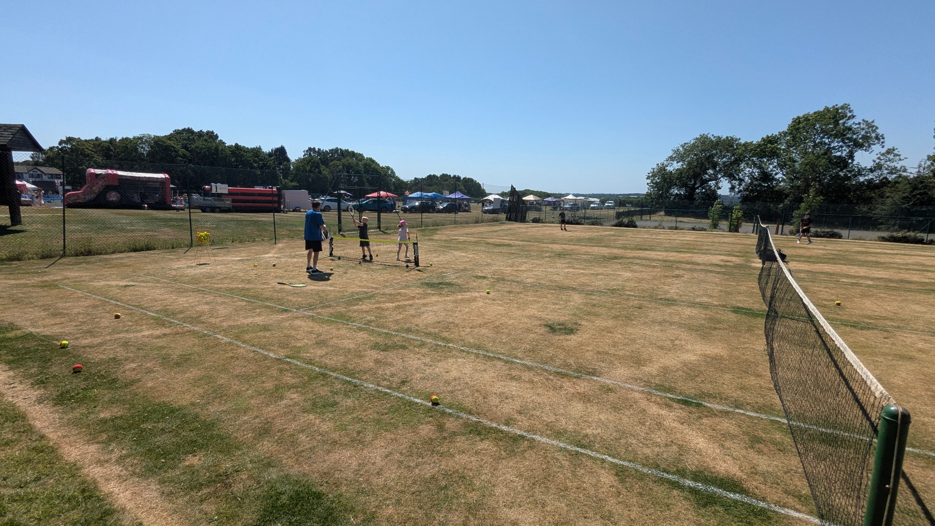 Wider view of the courts and the village fete beyond